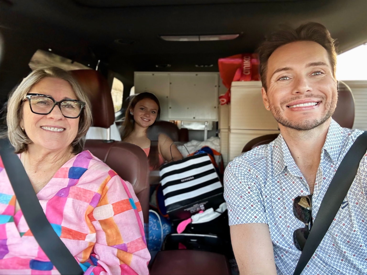 Gigi, Perry Kate and Clayton traveling together in a packed vehicle for boarding-school move-in