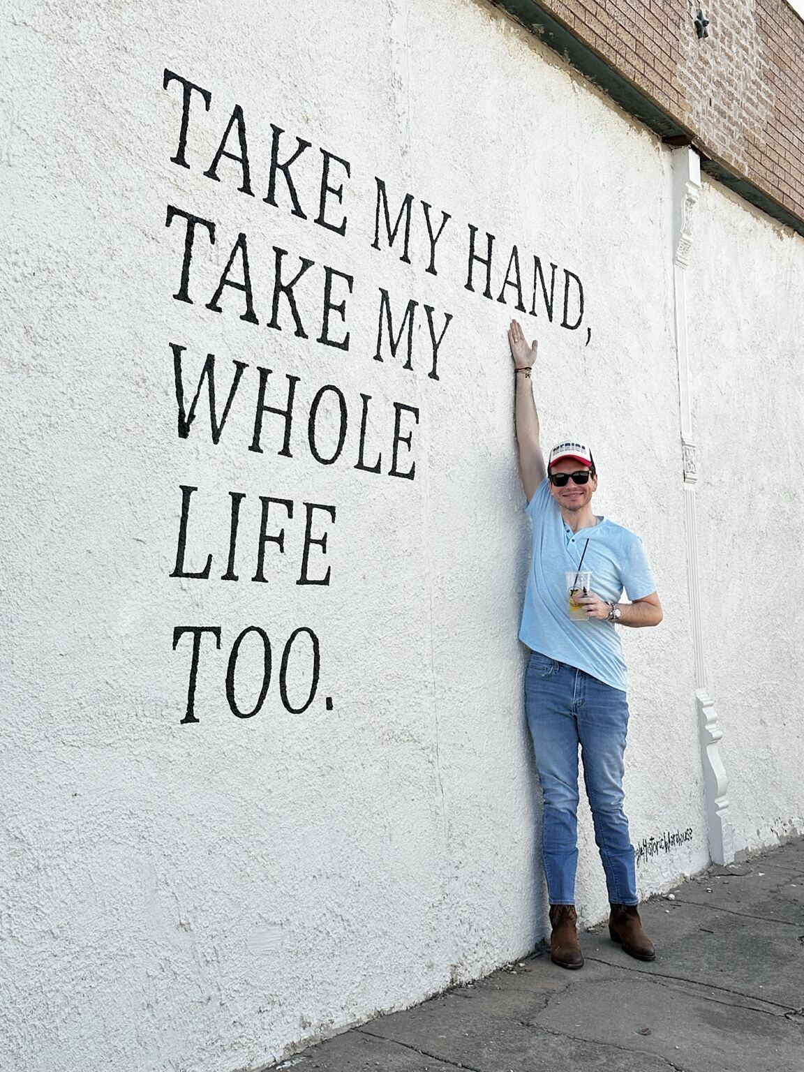 Clayton Hollingsworth standing beside the Take My Hand Take My Whole Life Too mural in Hillsboro