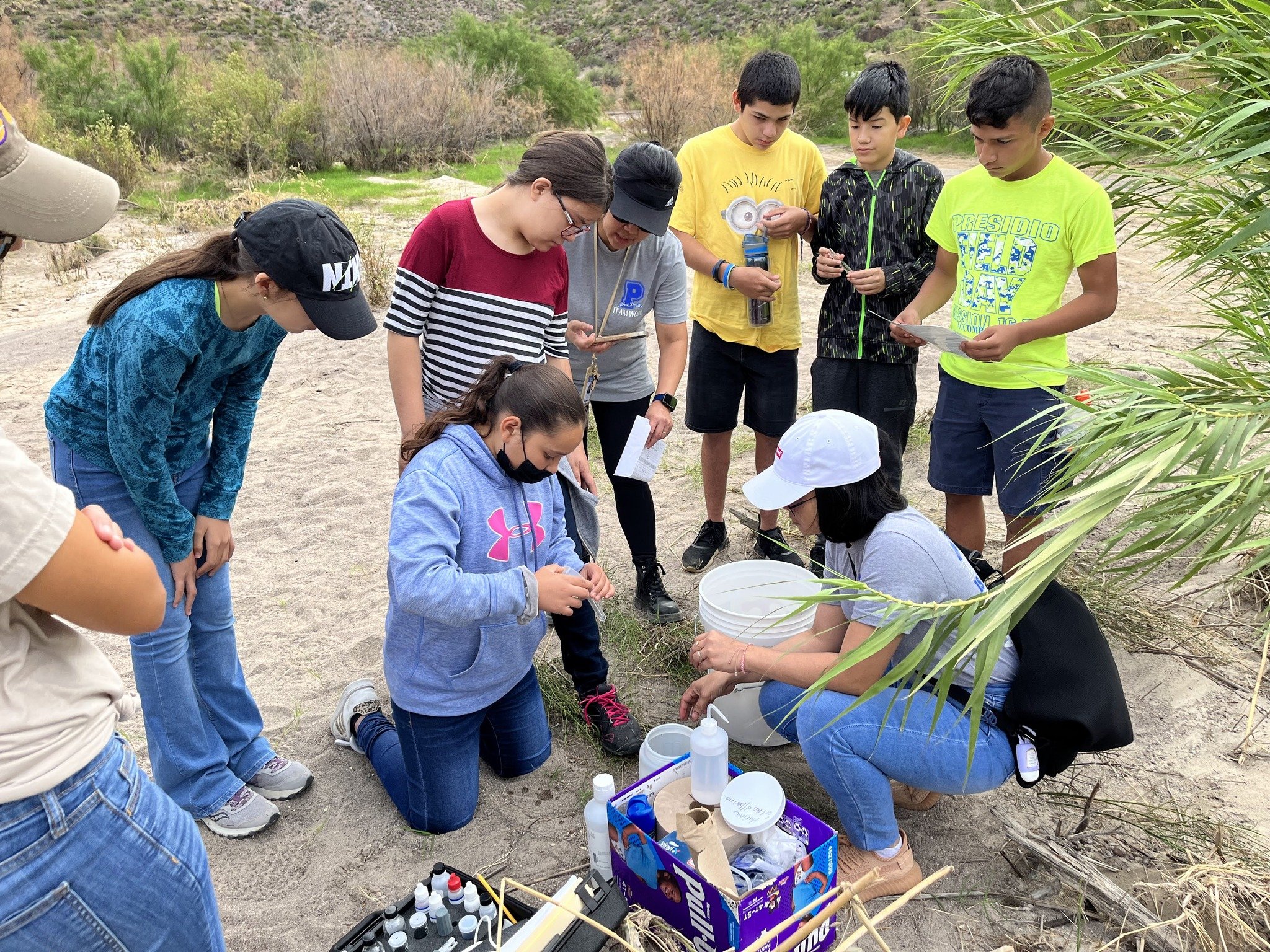 River Rangers gather around water-testing equipment during a Big Bend field trip.