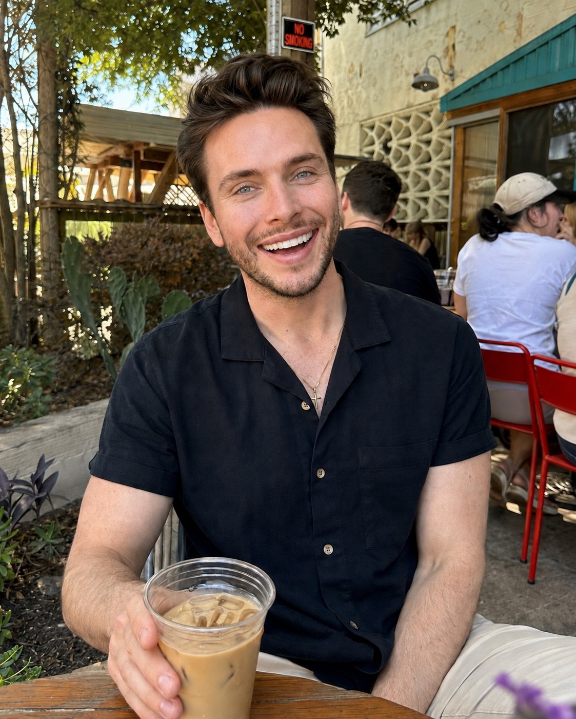 Clayton Hollingsworth seated outdoors with a cup of coffee